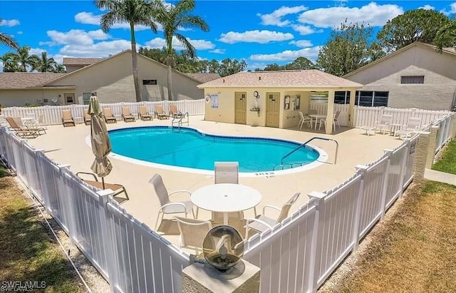 community pool featuring a patio area and a fenced backyard