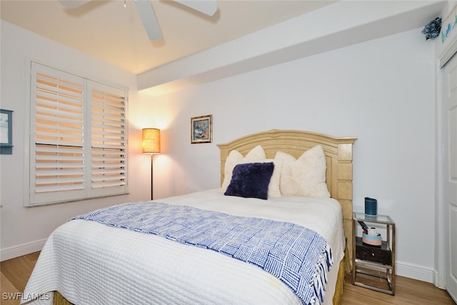 bedroom featuring a ceiling fan, baseboards, and wood finished floors