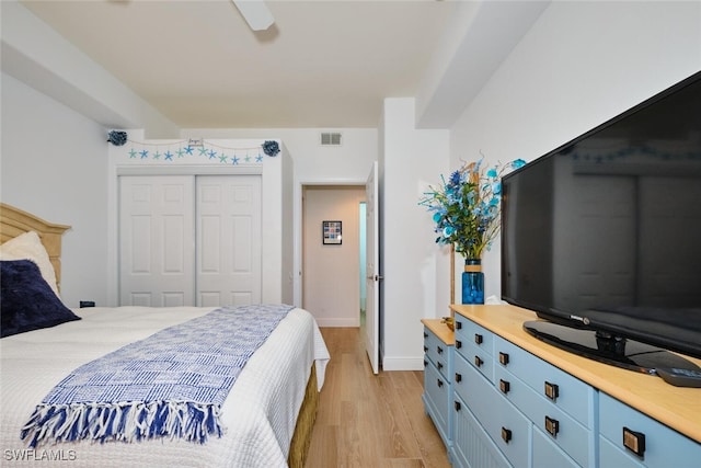 bedroom with light wood-type flooring, visible vents, a closet, baseboards, and ceiling fan