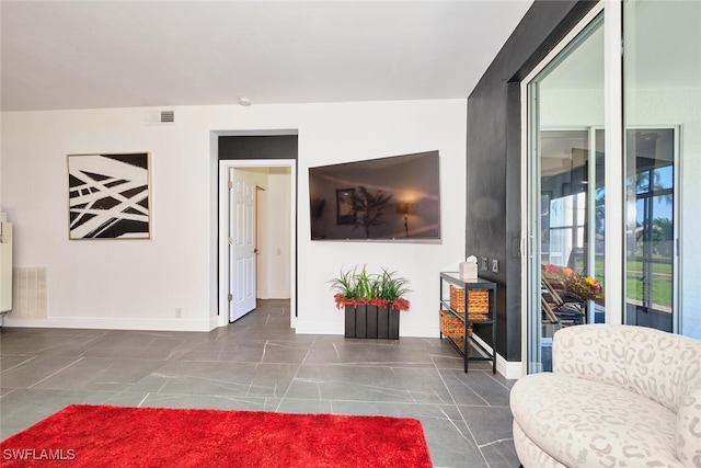 tiled living room with baseboards and visible vents