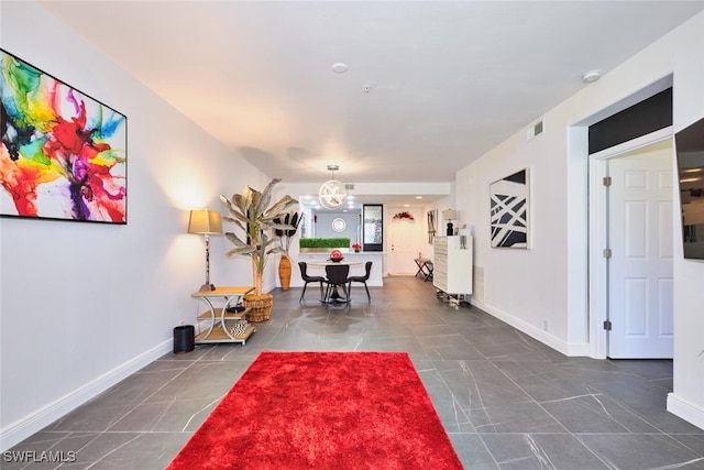 interior space with tile patterned floors, baseboards, visible vents, and a chandelier