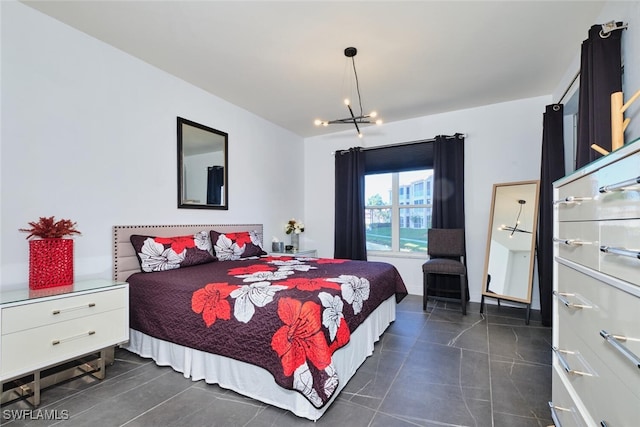 bedroom featuring dark tile patterned floors and a chandelier