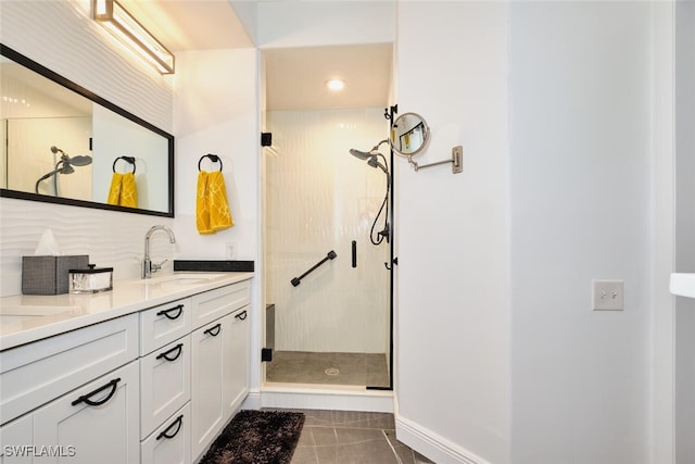 full bath with tile patterned floors, a shower stall, vanity, and baseboards