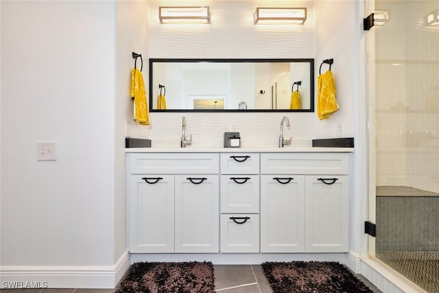 bathroom with a sink, a stall shower, double vanity, and tile patterned floors