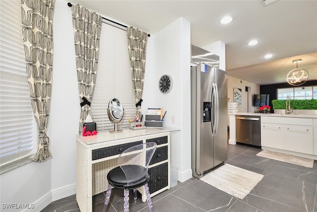 kitchen featuring dark tile patterned flooring, a sink, recessed lighting, stainless steel appliances, and white cabinets