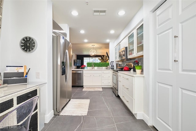 kitchen featuring visible vents, recessed lighting, appliances with stainless steel finishes, white cabinetry, and backsplash