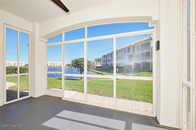 unfurnished sunroom with a water view