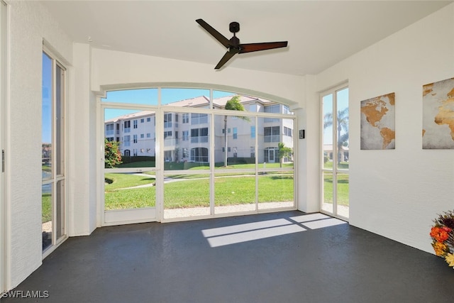 unfurnished sunroom featuring plenty of natural light and ceiling fan