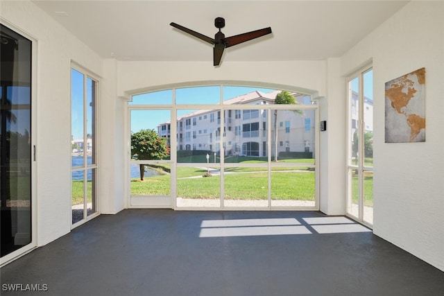 unfurnished sunroom with a wealth of natural light and ceiling fan