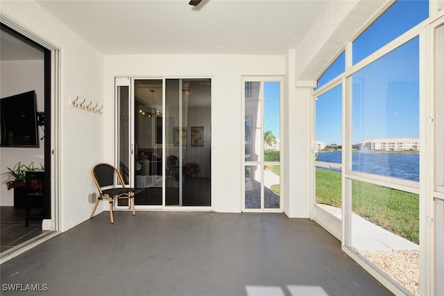 unfurnished sunroom featuring a water view