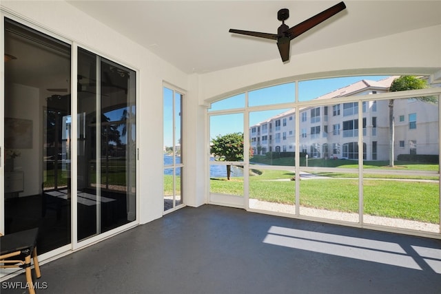 unfurnished sunroom with ceiling fan