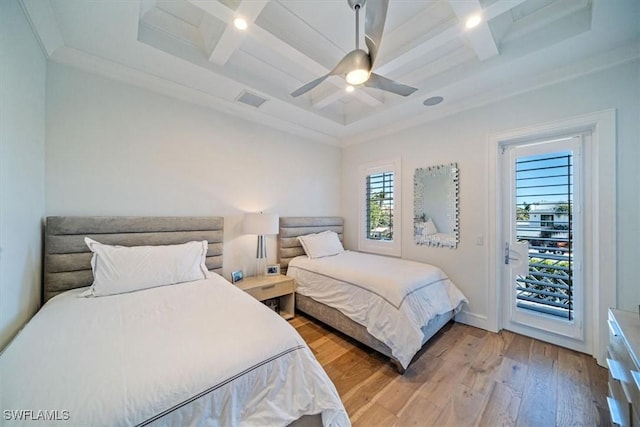 bedroom with light wood-type flooring, visible vents, a ceiling fan, access to outside, and a tray ceiling