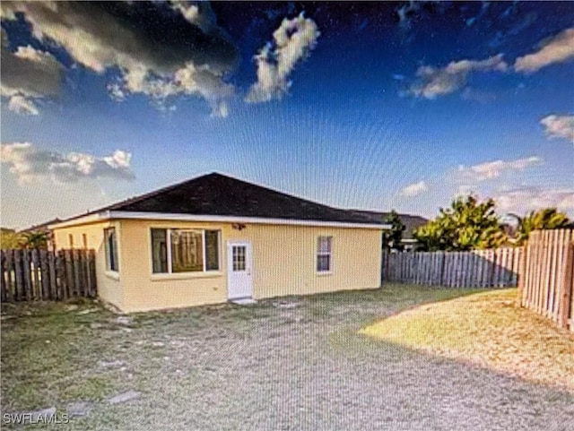 rear view of house with a fenced backyard