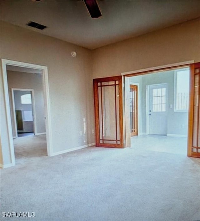 unfurnished bedroom featuring visible vents, carpet, and ceiling fan