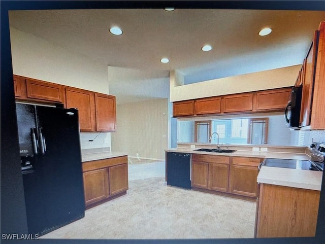 kitchen featuring brown cabinets, black appliances, and a sink