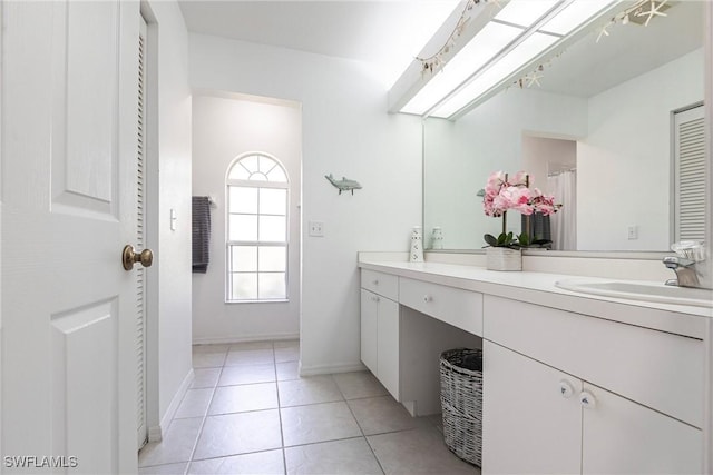 bathroom featuring tile patterned floors, baseboards, and vanity