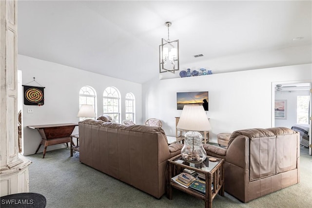 carpeted living room with a notable chandelier, visible vents, and lofted ceiling