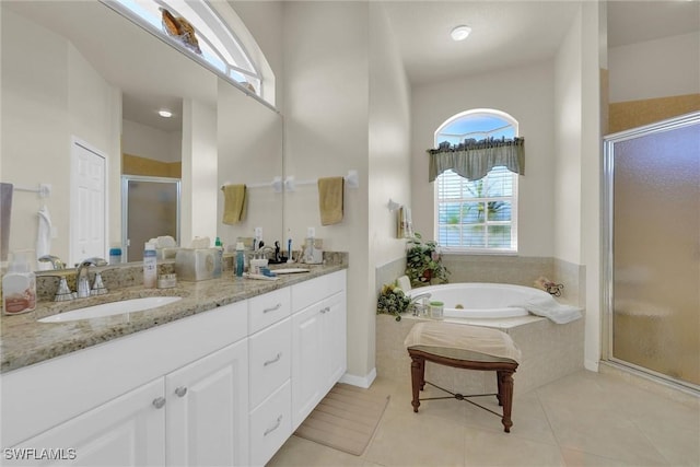 full bathroom featuring tile patterned flooring, double vanity, a stall shower, a bath, and a sink