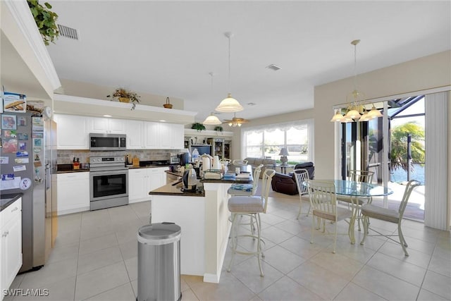 kitchen featuring decorative backsplash, dark countertops, white cabinetry, and stainless steel appliances