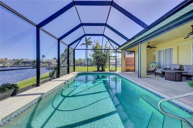 pool featuring a patio area, glass enclosure, ceiling fan, and a water view