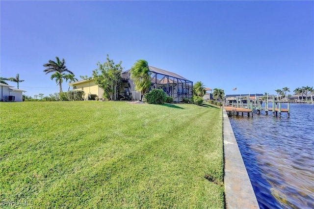 dock area featuring a lanai, a yard, and a water view