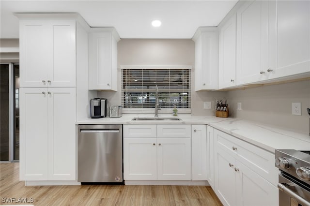 kitchen featuring a sink, light wood-style floors, white cabinetry, and stainless steel appliances