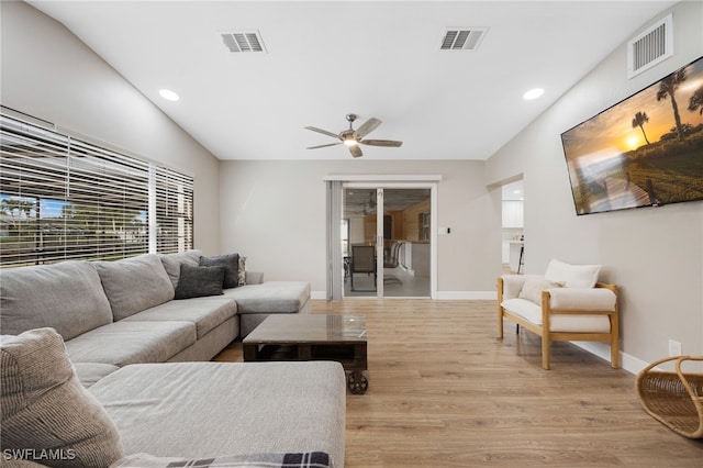 living room with visible vents, baseboards, and light wood-style floors