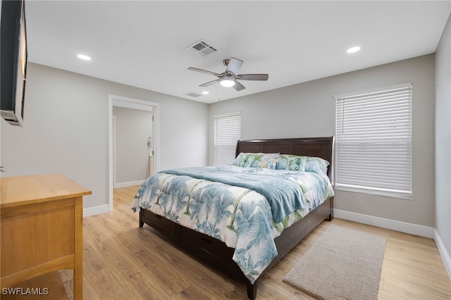 bedroom featuring visible vents, baseboards, and light wood finished floors