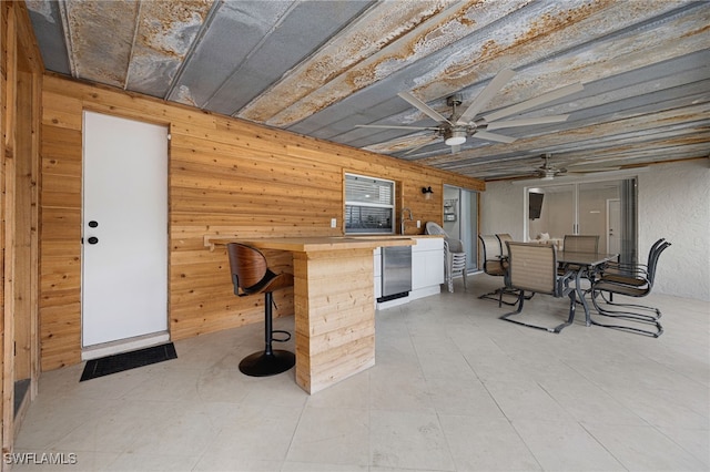 interior space with outdoor dry bar, outdoor dining space, and a ceiling fan