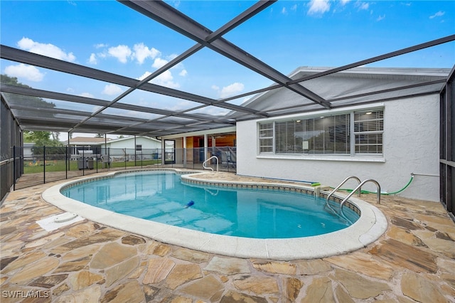 view of pool featuring glass enclosure, a patio area, and a fenced in pool