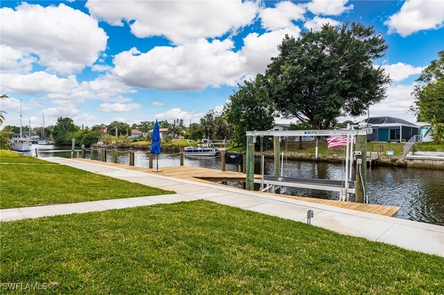 dock area with a lawn, a water view, and boat lift