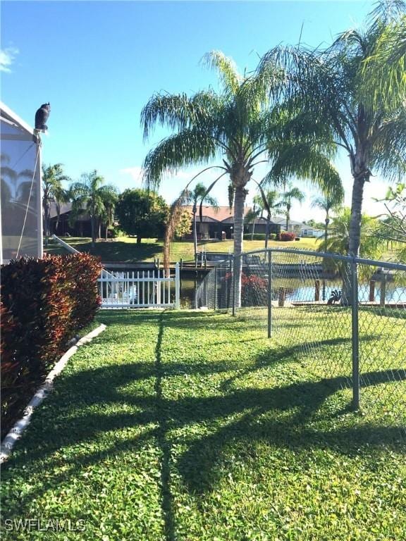 view of yard featuring a water view and fence