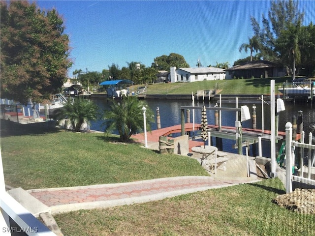 exterior space featuring boat lift, a lawn, and a water view