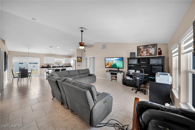 living area with light tile patterned floors, visible vents, ceiling fan, and vaulted ceiling