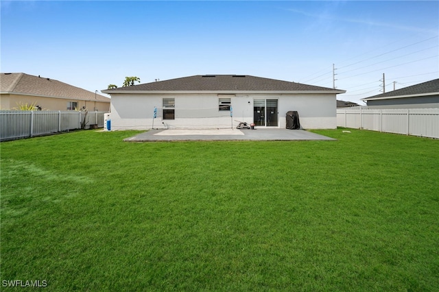 back of house with a yard, a fenced backyard, and stucco siding