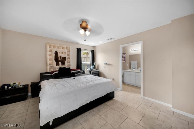 bedroom with ensuite bath, light tile patterned flooring, baseboards, and visible vents