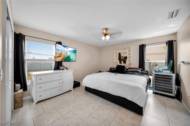 bedroom featuring light tile patterned floors, visible vents, baseboards, and ceiling fan