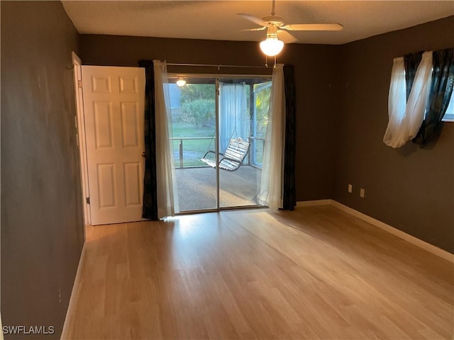 unfurnished room featuring wood finished floors, baseboards, and ceiling fan