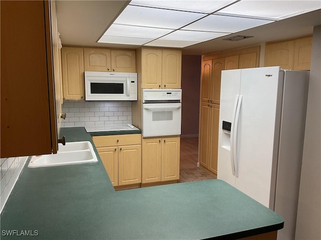 kitchen featuring decorative backsplash, white appliances, a sink, and light brown cabinetry