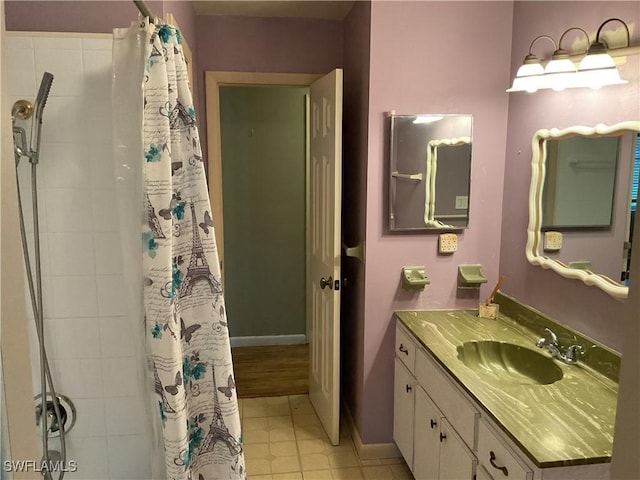 bathroom featuring curtained shower, vanity, and baseboards