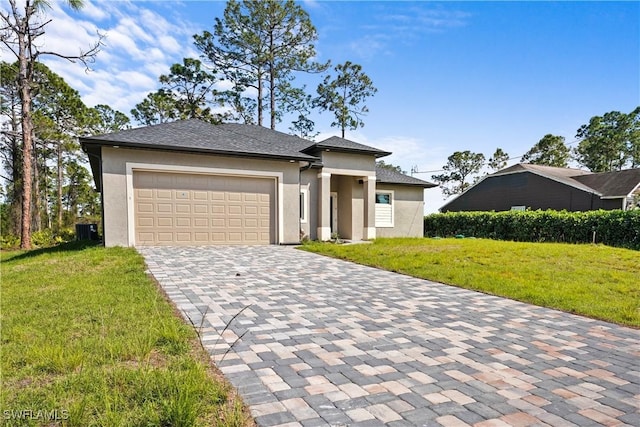 223 Corvet Ave, Lehigh Acres, FL 33974 - prairie-style house featuring a front lawn, decorative driveway, a garage, and stucco siding