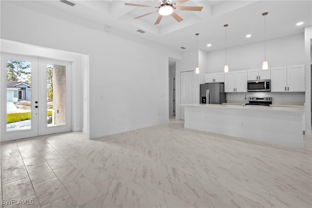 kitchen with white cabinetry, coffered ceiling, stainless steel appliances, and a high ceiling