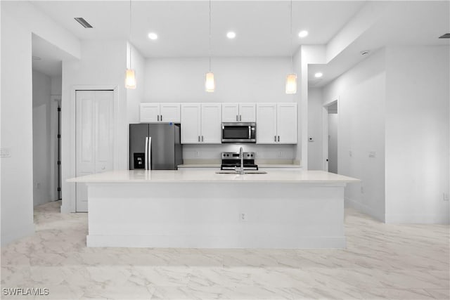 kitchen featuring a sink, stainless steel appliances, white cabinets, and a towering ceiling