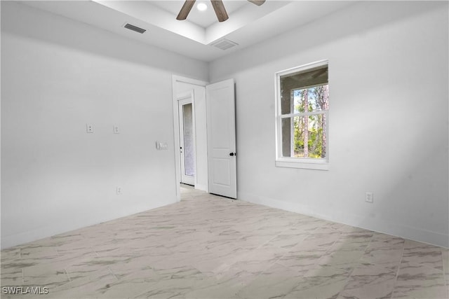 empty room with visible vents, marble finish floor, and ceiling fan