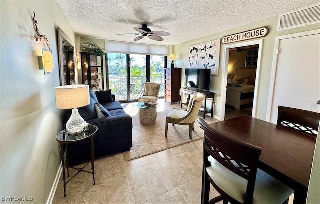 living room featuring baseboards, visible vents, a textured ceiling, and ceiling fan