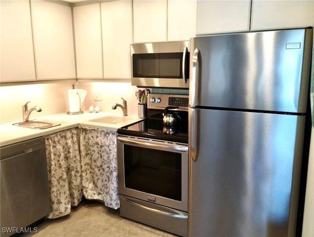 kitchen featuring white cabinetry, light countertops, appliances with stainless steel finishes, and a sink