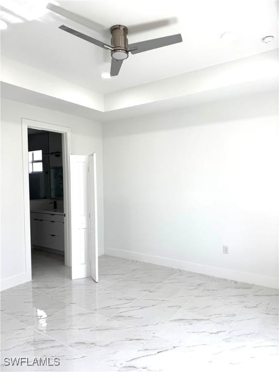 unfurnished bedroom with a ceiling fan, baseboards, and marble finish floor