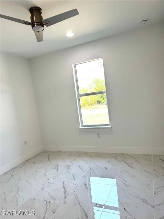 empty room with recessed lighting, marble finish floor, a ceiling fan, and baseboards