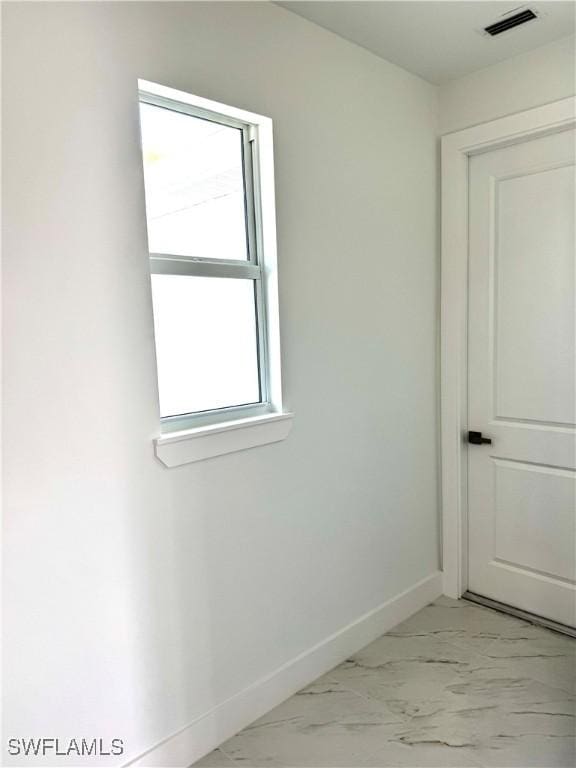 empty room featuring baseboards, visible vents, and marble finish floor