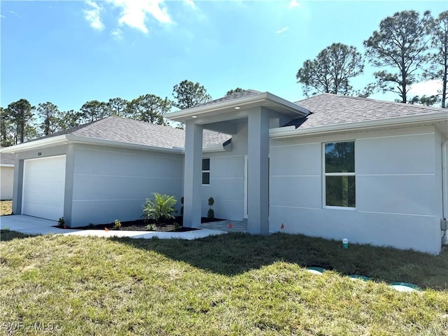 view of front facade with a front lawn, a garage, roof with shingles, and stucco siding